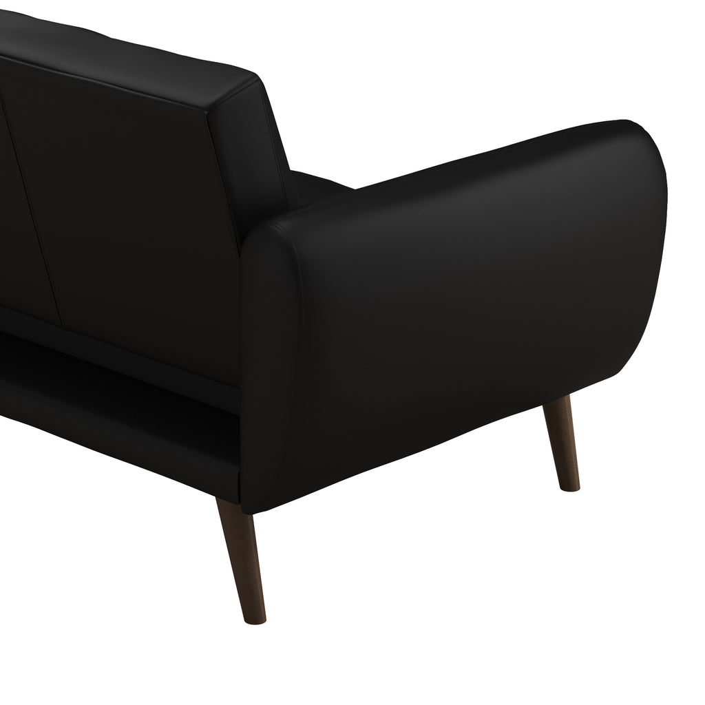 The Brittany Futon - Faux Leather is a sleek black sofa with wooden legs and contemporary design, featuring slightly curved armrests and a streamlined backrest. Its versatile futon style is enhanced by the warmth of its wooden legs, as seen from a rear angle.