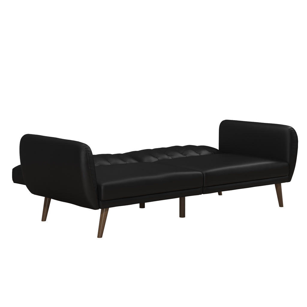 The Brittany Futon - Faux Leather in sleek black features tufted faux leather upholstery and wooden legs. It showcases a modern minimalist style with clean lines and a multi-position split-back design, shown here in its flat, bed-like position.