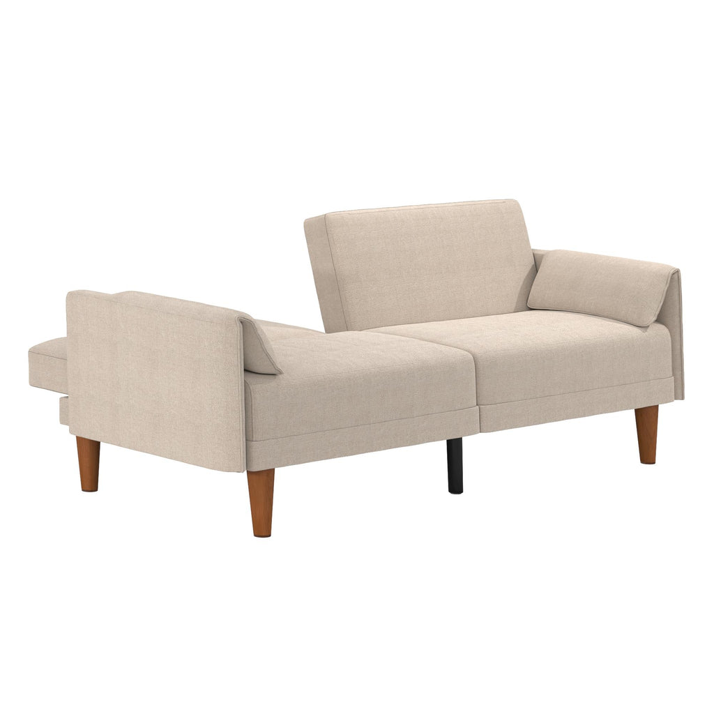 The Markham Futon is a beige sectional sofa with wooden legs, featuring two cushioned sections extending in opposite directions for an open, contemporary look reminiscent of midcentury modern design.