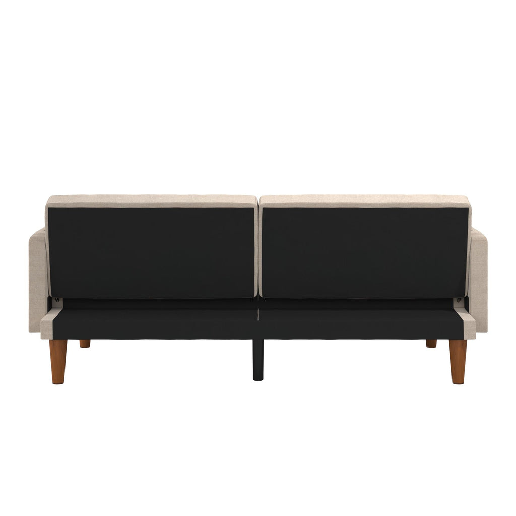 The Markham Futon features a modern Scandinavian design, visible from the back view, with a beige top section and black bottom. It stands on wooden legs and boasts a minimalistic style.